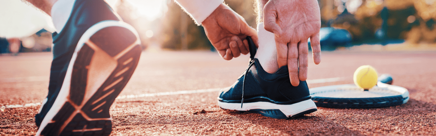 tennis player putting on shoe